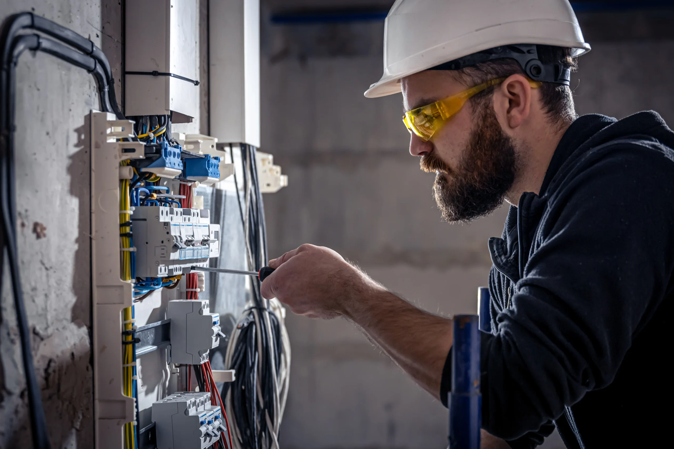 male-electrician-works-switchboard-with-electrical-connecting-cable